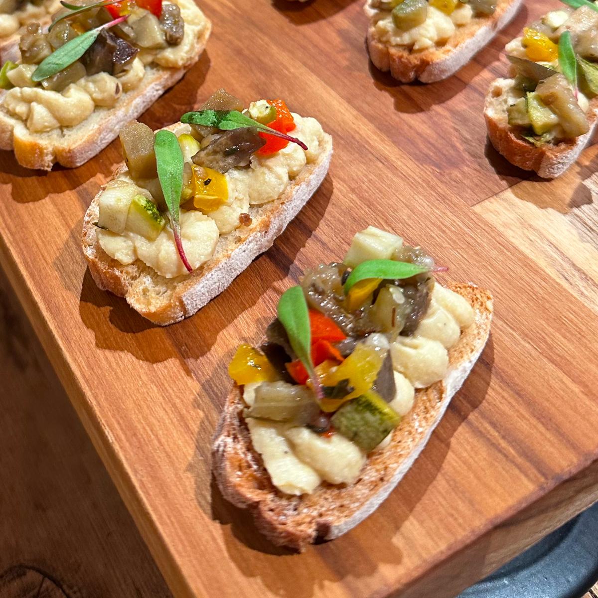 Bruschettas variadas dispostas sobre tábua de madeira