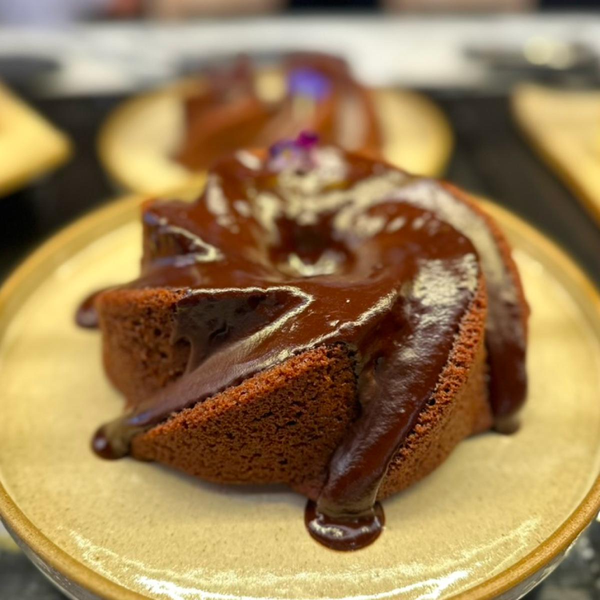 Bolo com calda de chocolate escorrendo pelas laterais