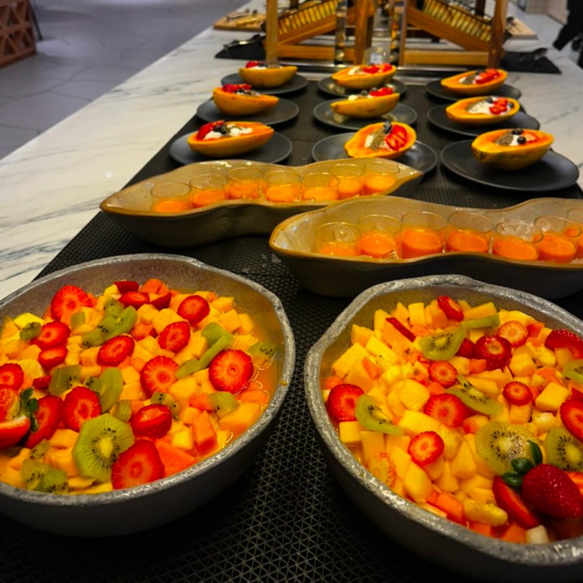 Buffet com saladas de frutas e tarteletes coloridas