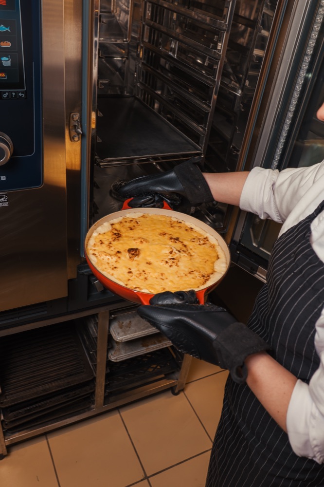 Prato gratinado sendo retirado do forno